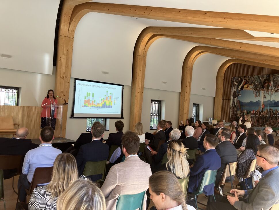 a women giving a powerpoint presentation to a room full of people.